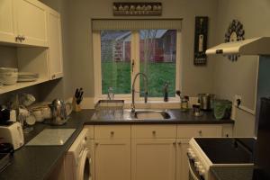 eine Küche mit einem Waschbecken und einem Fenster in der Unterkunft Hot Tub Hideaway in Hemyock