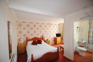 
a bedroom with a bed and a dresser at The Curraghmore in Shanklin

