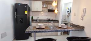 a kitchen with a black refrigerator and a counter with two cups at Moderno Loft Fiscalía in Bucaramanga