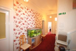 a living room with a fish tank on a wall at The Curraghmore in Shanklin