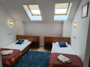 2 camas en una habitación con 2 ventanas en Hotel Sutoris, en Bochnia