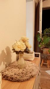 a vase with white roses in it on a table at Apartment mit schönem Ausblick in Lüdenscheid