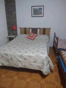 Un dormitorio con una cama con una manta. en Depto Caeiro Santa María en Santa María