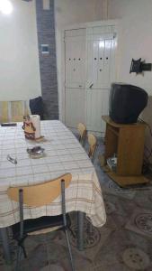 cocina con mesa y TV en una habitación en Depto Caeiro Santa María en Santa María
