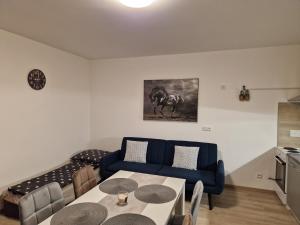 sala de estar con sofá azul y mesa en Apartmán NH Stables, en Nýřany