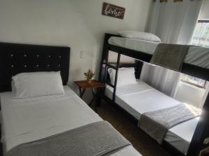 3 Etagenbetten in einem Zimmer mit Fenster in der Unterkunft House Hotel Sweet Home 2 apartments in Medellín