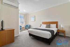 a hotel room with a bed and a television at Villa 55 by the Waters Edge in Mandurah