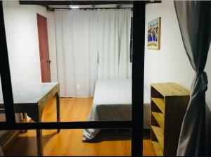 a bedroom with a bed and a desk and a window at Alojamiento Cuarto Espiral in Manizales