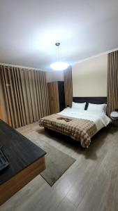a bedroom with a bed and a table in it at Vila Bakri Couple Room in Elbasan