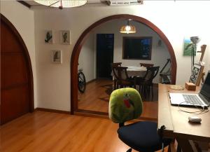 a room with a table and a chair with a laptop at Alojamiento Cuarto Espiral in Manizales
