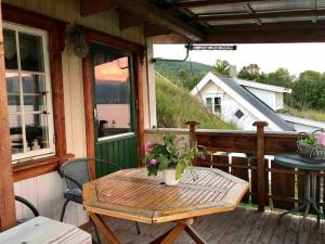 einem Holztisch auf der Veranda einer Hütte in der Unterkunft House by the Sea in Sortland