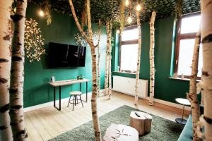 a room with green walls and trees and a desk at SECRET HIDEAWAYS Wood Lodge mit Kinderzimmer Messe l City l Flughafen l Hbf in Duisburg