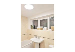 a bathroom with a sink and a bath tub at A Home from Home - Leamington Spa in Leamington Spa
