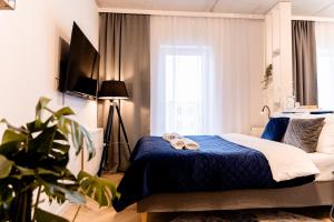 a bedroom with a bed with a stuffed animal on it at Hop & Lulu Delux Apartments in Goleniów