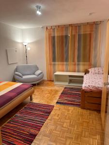 a bedroom with a bed and a couch and a chair at Premium Handwerker Zimmer in Balingen