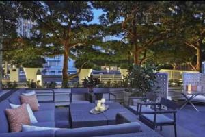 un patio con sofás azules, mesas y árboles en 43rd Floor Icon Brickell Ocean &Pool View Free SPA, en Miami