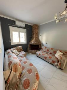 salon z 2 łóżkami i kominkiem w obiekcie Σπίτι στα Βασιλικά Σαλαμίνας w mieście Salamina