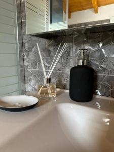 a bathroom sink with a black soap dispenser on it at Karmen House in Salamina +13 photos