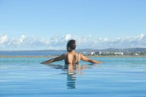 mężczyzna siedzący w wodzie w basenie w obiekcie Nalagi Hotel w mieście Nadi