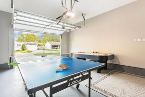 a ping pong room with a ping pong table at ATLAS - Whole House - 5BR 2BA - Hot Tub - Game Rooms - Theater - Fenced Backyard in Muskegon