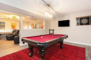 a room with a pool table in a living room at ATLAS - Whole House - 5BR 2BA - Hot Tub - Game Rooms - Theater - Fenced Backyard in Muskegon