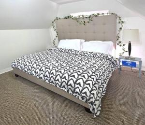 a bedroom with a bed with a black and white comforter at St. James Haven: 2-Bed & office in Winnipeg