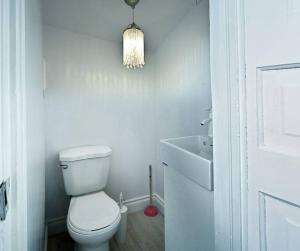a white bathroom with a toilet and a sink at St. James Haven: 2-Bed & office in Winnipeg