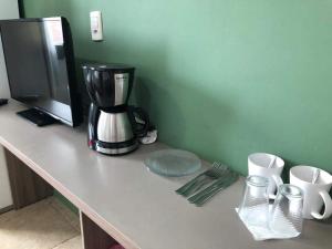 a counter with a coffee maker and cups on it at Savanna Suites - Beto Carrero in Penha
