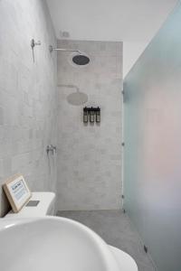 uma casa de banho com um WC branco e um chuveiro em 4 You Hotel Nosara em Playa Guiones