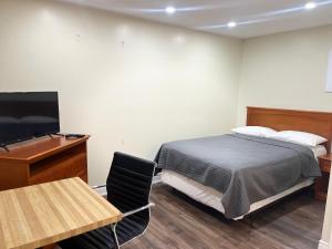 a bedroom with a bed and a desk and a television at Cedar Springs Motel in Acton