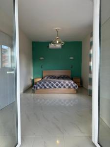 um quarto com uma cama e uma parede verde em Σπίτι στα Βασιλικά Σαλαμίνας em Salamina