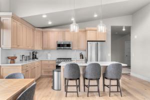 a kitchen with wooden cabinets and a island with bar stools at Luxury Stays Club, B6 304 in Cranmer