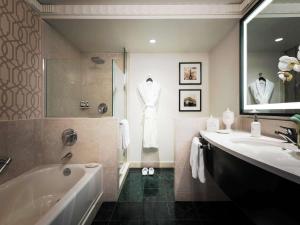 a bathroom with a bath tub and a sink at Sofitel Lafayette Square Washington DC in Washington, D.C.