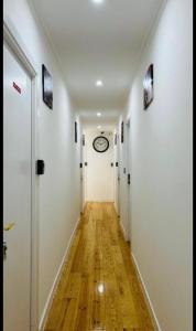 a hallway with white walls and a clock on the wall at Suites Luciano Cordeiro in Lisbon