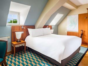 a bedroom with a large white bed and a window at Sofitel Grand Sopot in Sopot