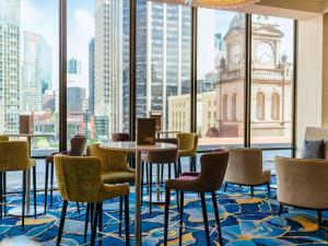 Pokój ze stołem i krzesłami oraz dużym oknem w obiekcie Sofitel Brisbane Central w mieście Brisbane