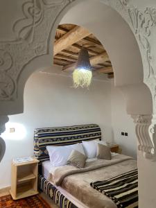 a bedroom with a bed in a room with a ceiling at Tafsut dades guesthouse stay with locals in Tamellalt