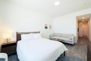 a bedroom with a large white bed and a chair at Pioche Village in Park City