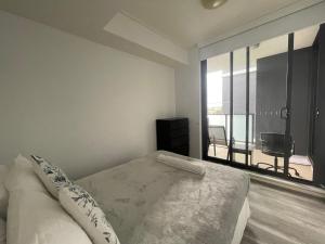 ein weißes Schlafzimmer mit einem Bett und einem großen Fenster in der Unterkunft Entire 2 bedrooms Security Apartment in Riverwood + 8 Fotos