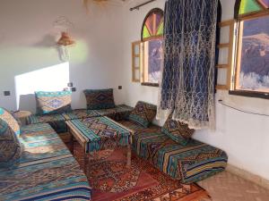 a living room with couches and a window at Tafsut dades guesthouse stay with locals in Tamellalt