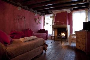 sala de estar con cama y chimenea en Locanda Al Cappello, en Udine