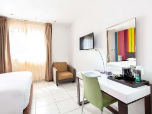 阿克拉的住宿－阿克拉機場宜必思尚品酒店，酒店客房配有书桌和床。