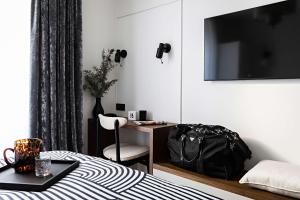 a bedroom with a bed and a desk with a bag at Best Western Premier The Blake Paris Gare Saint Lazare in Paris