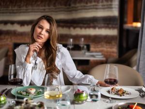 奧克蘭的住宿－索菲特奧克蘭高架橋港酒店，坐在餐桌上吃一盘食物的女人