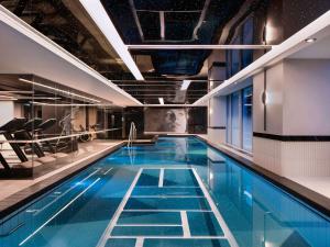a large swimming pool in a building at Sofitel Auckland Viaduct Harbour in Auckland