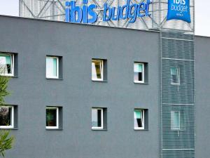 un bâtiment gris avec un panneau sur son côté dans l'établissement Ibis Budget Sarrebourg Buhl, à Sarrebourg