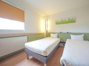 Postel nebo postele na pokoji v ubytování Ibis Budget Sarrebourg Buhl