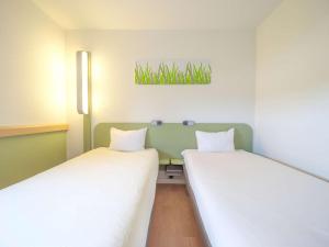 Postel nebo postele na pokoji v ubytování Ibis Budget Sarrebourg Buhl