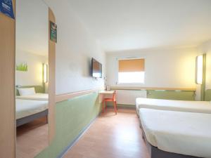 Postel nebo postele na pokoji v ubytování Ibis Budget Sarrebourg Buhl