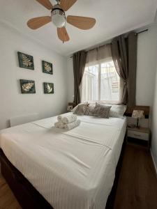 a bedroom with a large white bed with a ceiling fan at Sonido del Mar in Gran Alacant +33 photos